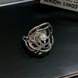 Vista dettagliata di una pinza per capelli in metallo argento a forma di rosa con perla