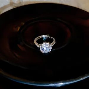 Detailed macro view showing the sparkling round zircon and halo design of the silver open ring