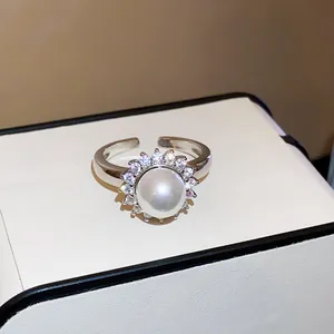 Macro view of a silver open ring featuring a large pearl and sparkling zircon halo