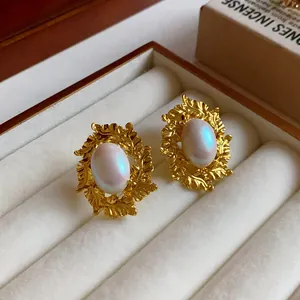 Macro view of vintage gold leaf earrings with iridescent oval pearl in a jewelry box