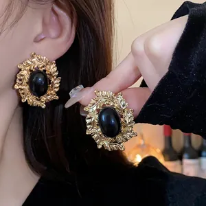 Vintage gold leaf earrings featuring oval black gemstone for an elegant retro style look