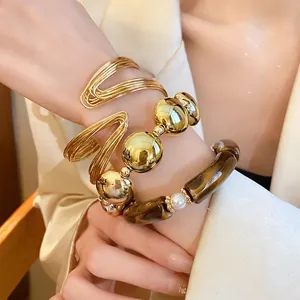 Elegant stackable bracelet set featuring metallic beads, acrylic tubes, and pearls