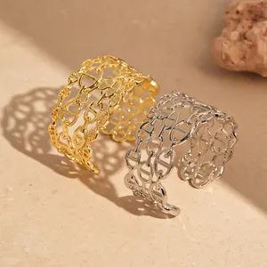 Dettaglio di bracciali a polsino multistrato con motivo a naso di maiale in oro e argento