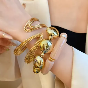 Detail shot of a stylish metal and acrylic bead elastic bracelet set on a woman's wrist
