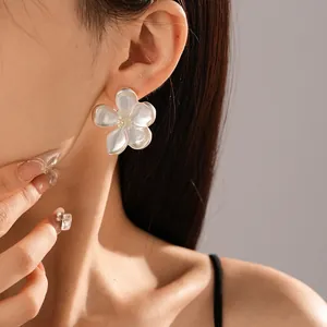 Pendiente de botón con elegante flor blanca de cinco pétalos, primer plano en modelo