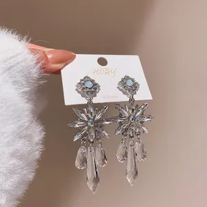 Close-up of elegant crystal flower drop earrings with sparkling teardrop pendants