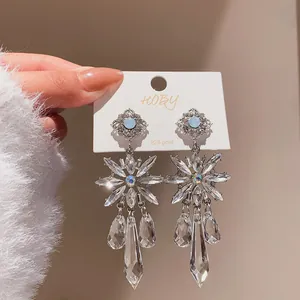 Macro view of crystal flower dangle earrings with teardrop drops on 925 silver post.