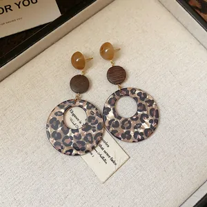Detailaufnahme von Vintage-Ohrringen aus Harz mit Leopardenmuster und Holz in Braun