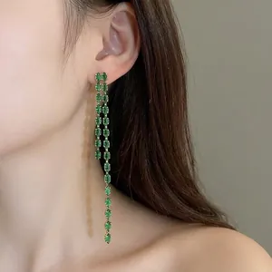 Orecchini lunghi a nappa con zirconi marquise verdi brillanti indossati da modella