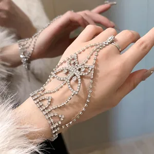 Vista detallada de una pulsera de mano con mariposa de diamantes de imitación en una mano cuidada.
