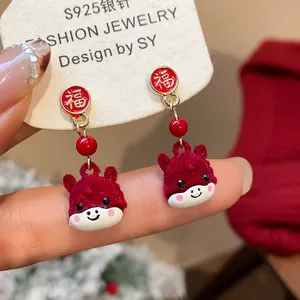 Primo piano degli orecchini a forma di cavallino rosso floccato con ciondolo Fu.