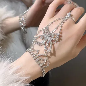 Primer plano de una elegante pulsera de mano con mariposa de pedrería plateada en la mano
