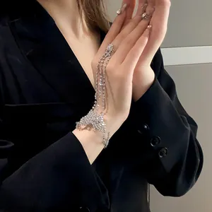 Primer plano de joya de mano mariposa con diamantes de imitación y cadenas largas