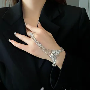 Detalle de primer plano de una pulsera de mano con mariposa de strass en una mano
