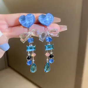 Detailansicht der böhmischen Retro-Ohrringe mit blauem Herz, Schleife und bunten Edelsteinen