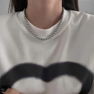 Vintage silver bead choker necklace elegantly styled on a model with a white t-shirt