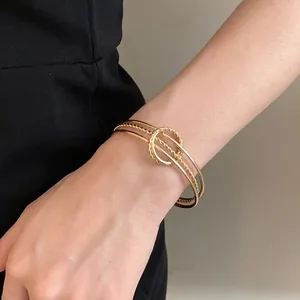 Elegante bracciale rigido aperto dorato irregolare con design minimalista alla moda