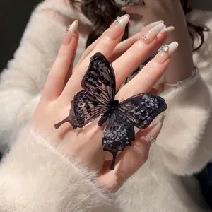 Detailed shot of an elegant black butterfly open ring with sparkling glitter accents