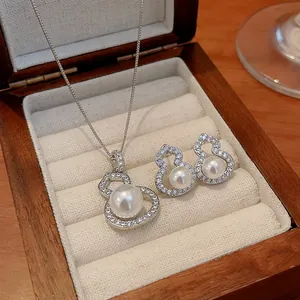 Elegant pearl and zircon gourd jewelry set displayed in a premium wooden box.