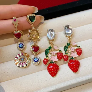 Detailansicht von ländlichen Erdbeeren und Herzohrringen mit bösem Blick und Zirkon