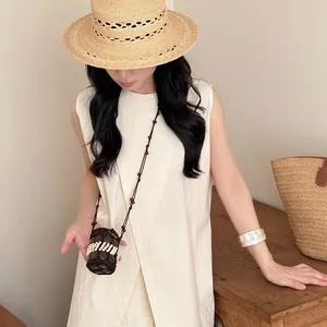 Mini bolso bohemio de cáscara de coco tejido a mano usado como collar decorativo.