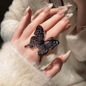 Detailed macro view of an elegant black mesh butterfly open ring on a woman's hand