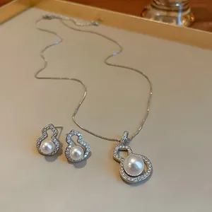 Elegant gourd-shaped jewelry set with pearls and zircons in a minimalist silver finish.