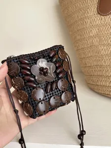 Primer plano de mini bolsa bohemia hecha a mano con cáscara de coco y flores