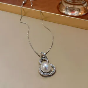 Detailed close-up of a silver gourd necklace with a lustrous pearl and CZ stones