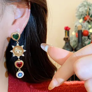 Detailansicht von Hängeohrringen mit Herzanhängern und einem bösen Blick Symbol