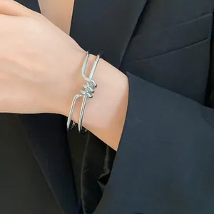 Vista dettagliata di un bracciale a polsino d'argento ritorto minimalista al polso