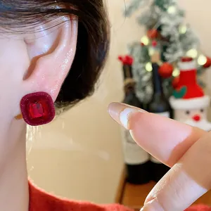 Close-up of red flocked square stud earring with faceted stone inlay