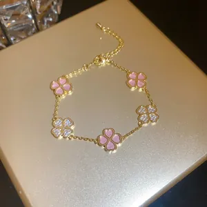 Macro shot of gold-plated clover bracelet featuring pink shell and shimmering zircons