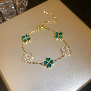 Detail of gold clover bracelet with green malachite and sparkling zircon motifs