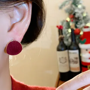Close-up shot of red flocked geometric stud earring with elegant soft velvet texture
