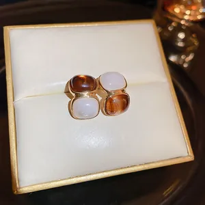 Elegant vintage square stud earrings with brown and white resin stones in a gold frame
