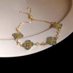 Close-up of elegant gold-plated four-leaf clover bracelet with turquoise and zircon