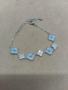 Detail of clover bracelet with pavé zircons and light blue stones in silver plating
