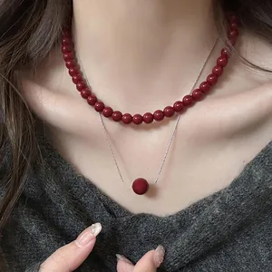 Detailed macro view of vintage Ankora red beaded necklace featuring a central lucky bead pendant