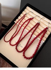 Red beaded necklaces in multiple sizes displayed elegantly in a jewelry box tray