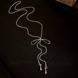 Elegant silver bowknot tassel adjustable lariat necklace for women on dark background