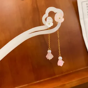 Primo piano di un elegante fermaglio per capelli in stile cinese con fiori e nappine rosa