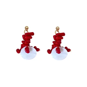Elegant red beaded drop earrings with white geometric shell accents and gold needle studs.