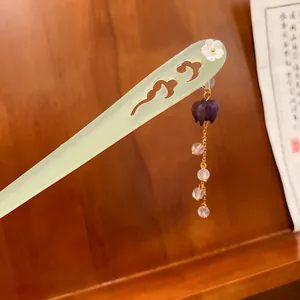 Primo piano di un elegante bastoncino per capelli cinese con fiore bianco e nappa