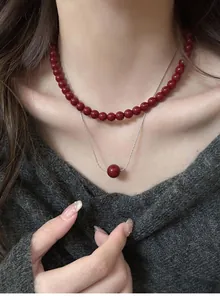 Close-up of vintage red bead necklace and silver pendant on a woman's elegant neck