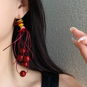 Close-up detail of elegant Hong Kong style red beaded tassel earrings with acrylic accents