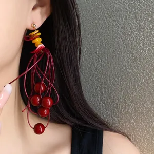 Elegant red acrylic beaded tassel earrings with geometric accents in a vintage style