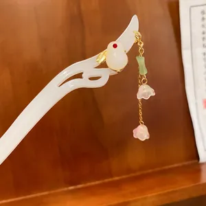 Primo piano di un fermaglio per capelli in stile cinese con coniglio di giada e fiori