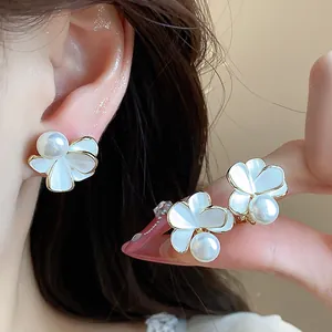 Dettaglio degli orecchini a fiore placcati in oro 18k con perle bianche lucide