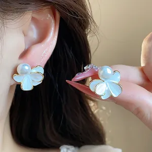 Dettaglio di orecchini a perla a fiore bianco con placcatura in oro 18k di lusso